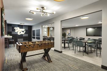 A game room with a foosball table and a tv
